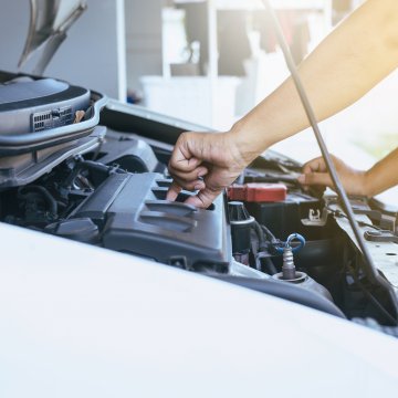 Open hood of a car closing the oil seal